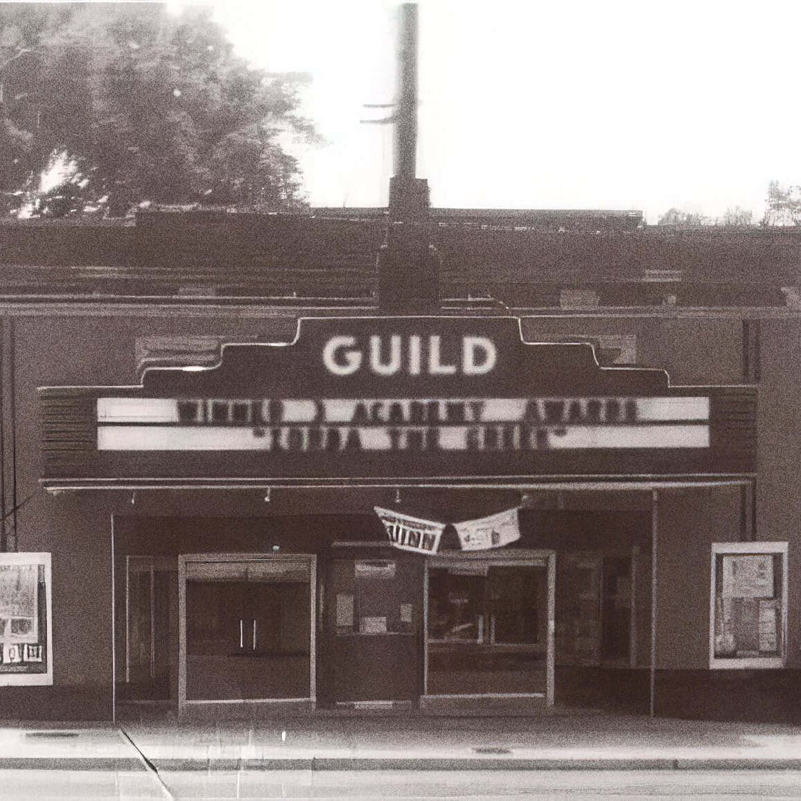 The Guild Theatre entrance with marquee and posters on each side.